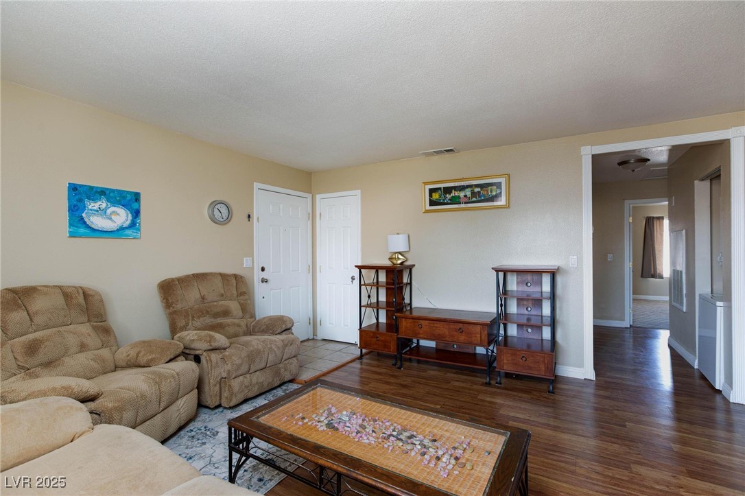 7300 West Pirates Cove Road, Unit 2038 Las Vegas, NV 89145 - Photo 4 of 26 Living room featuring wood finished floors and a textured ceiling