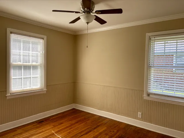 a view of a room with wooden floor and windows