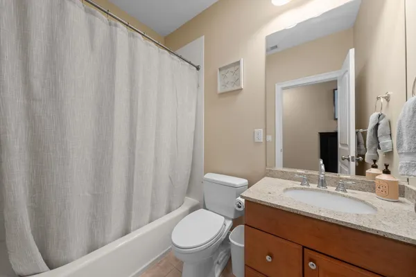 a bathroom with a granite countertop sink toilet and a mirror