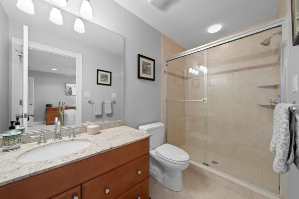 a bathroom with a granite countertop sink toilet and shower