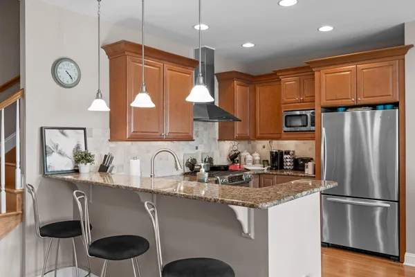 a kitchen with stainless steel appliances granite countertop a sink refrigerator and cabinets