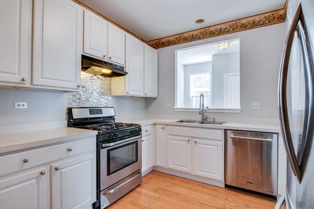 a kitchen with stainless steel appliances granite countertop a stove a sink and a refrigerator