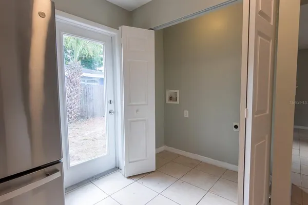 a kitchen with white cabinets appliances a sink and a window