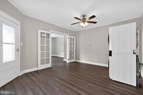 an empty room with wooden floor closet and windows
