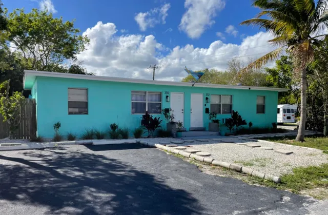 a front view of a house with garden and plants