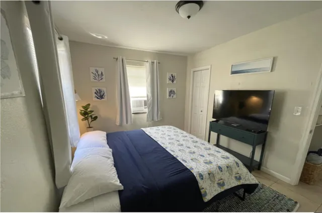 a bedroom with a bed and a flat screen tv