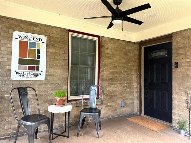 a front view of a house with outdoor seating and barbeque oven