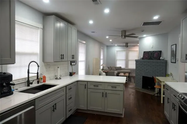 a kitchen with a sink dishwasher a stove and a refrigerator with wooden floor