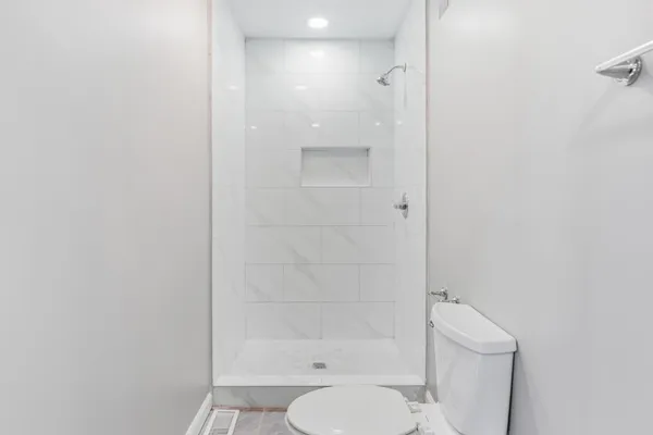 a bathroom with a shower a toilet and a sink