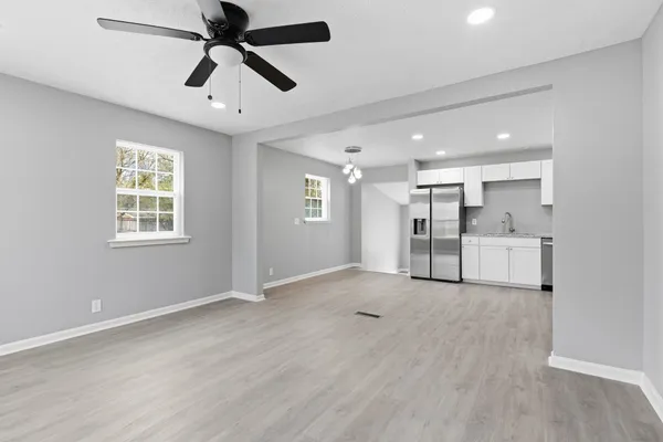 a view of empty room with wooden floor and window