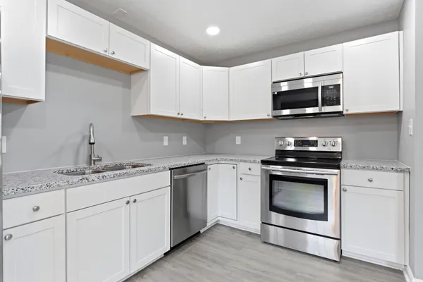 a kitchen with stainless steel appliances granite countertop a sink a stove a microwave and cabinets