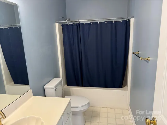 a bathroom with a toilet and a shower curtain