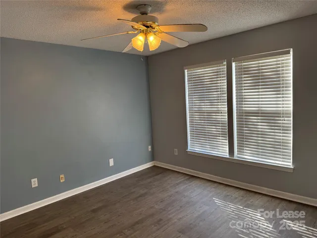 a view of an empty room with a window and a chandelier