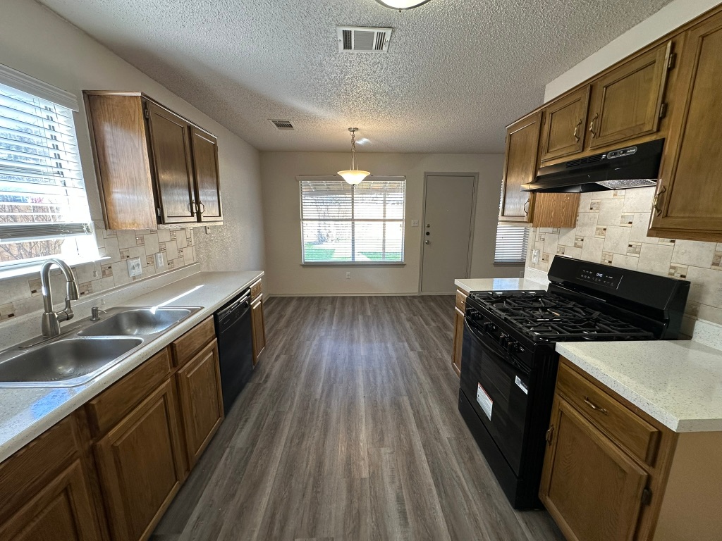 814 Smoke Signal Pass Pflugerville, TX 78660 - Photo 12 of 29 Kitchen featuring backsplash, black appliances, light countertops, healthy amount of natural light