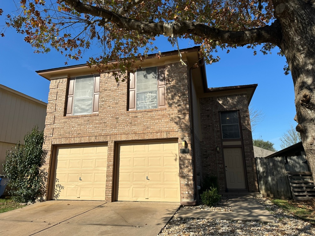 814 Smoke Signal Pass Pflugerville, TX 78660 - Photo 2 of 29 View of front facade featuring brick siding, driveway, and an attached garage