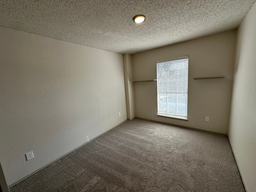 814 Smoke Signal Pass Pflugerville, TX 78660 - Photo 26 of 29 Carpeted spare room with a textured wall and a textured ceiling