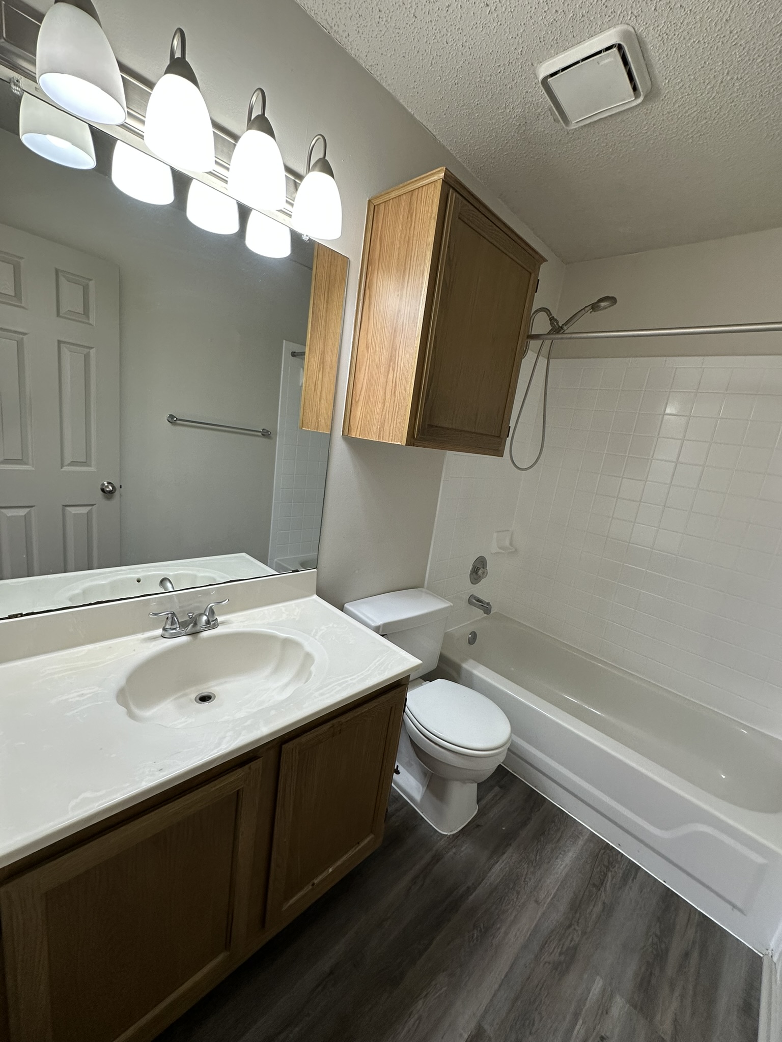 814 Smoke Signal Pass Pflugerville, TX 78660 - Photo 28 of 29 Full bathroom with vanity, bathing tub / shower combination, dark wood-style flooring, and a textured ceiling
