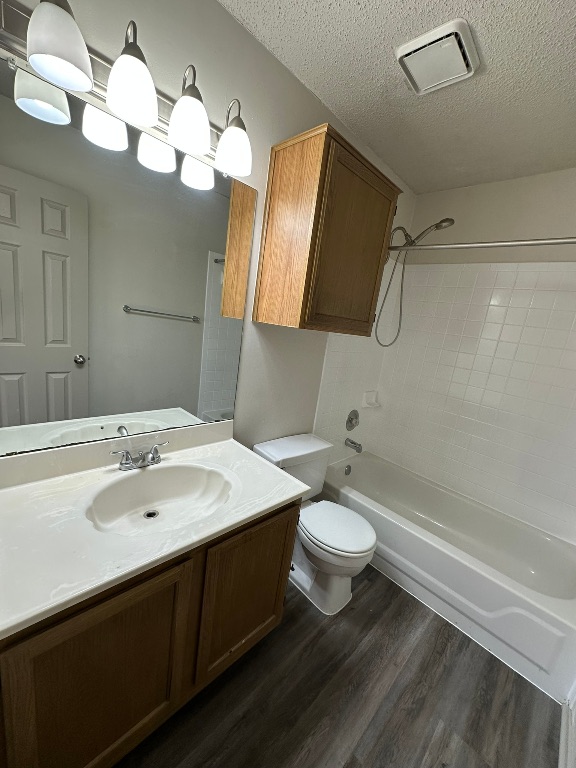 814 Smoke Signal Pass Pflugerville, TX 78660 - Photo 28 of 29 Full bathroom with vanity, bathing tub / shower combination, dark wood-style flooring, and a textured ceiling
