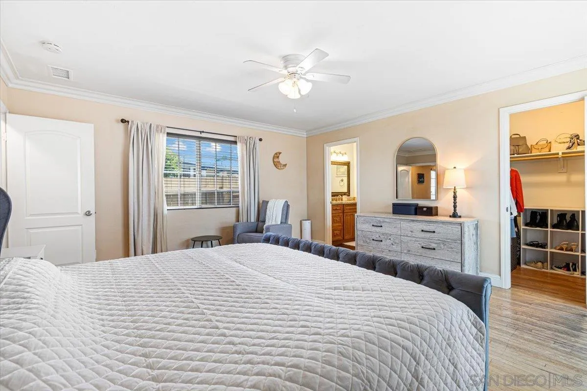 6295 Calle Pavana San Diego, CA 92139 - Photo 15 of 27 a bedroom with a large bed and wooden floor