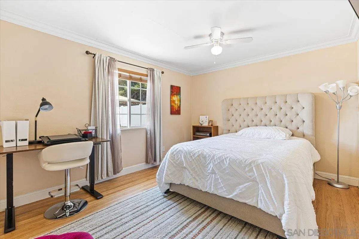 6295 Calle Pavana San Diego, CA 92139 - Photo 18 of 27 a bedroom with a bed a chandelier and a window