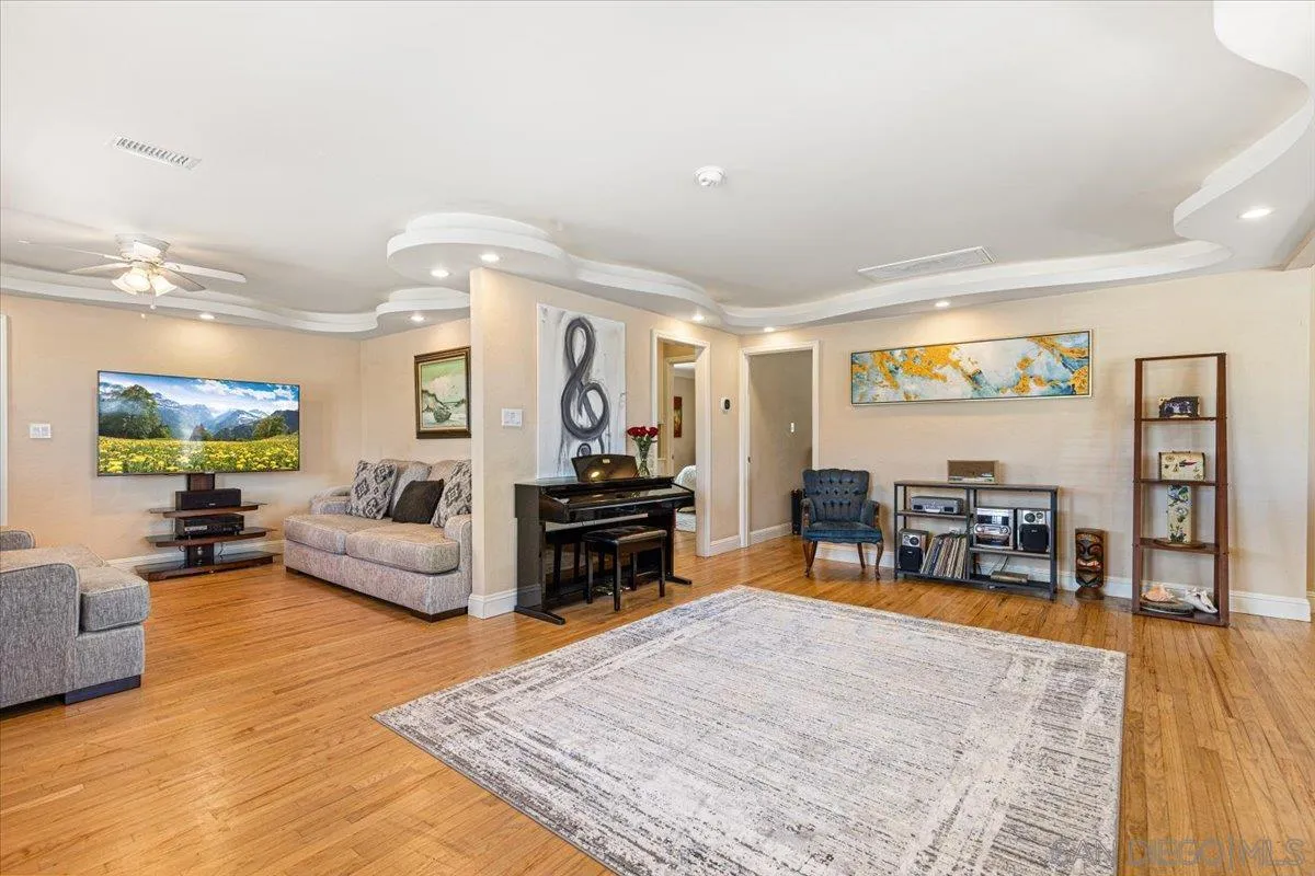 6295 Calle Pavana San Diego, CA 92139 - Photo 4 of 27 a living room with furniture and large wooden floor