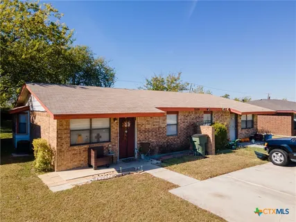 a patio with a table and chairs under an umbrella
