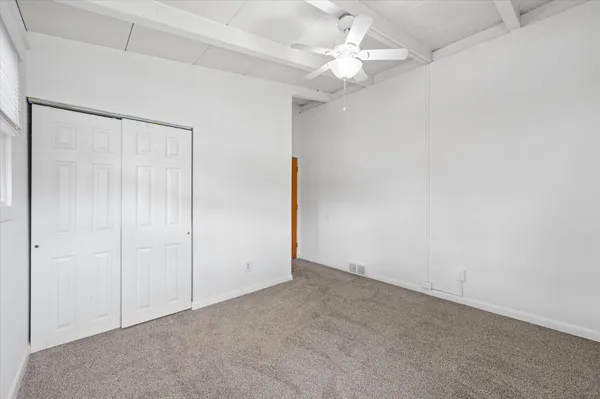 an empty room with a chandelier fan