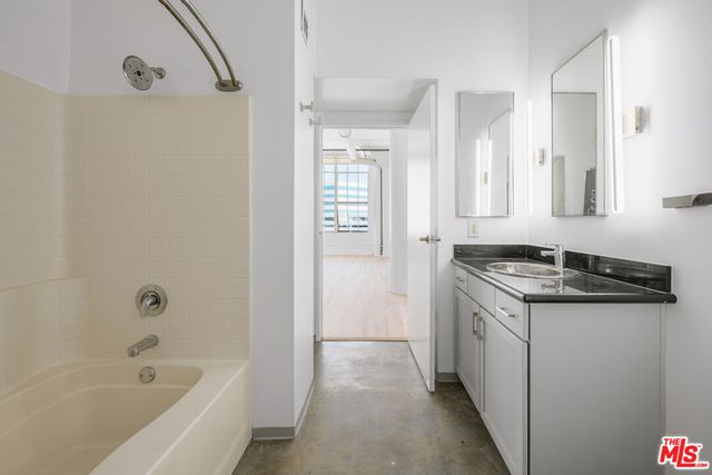a bathroom with a granite countertop sink a toilet and shower