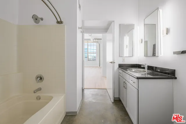a bathroom with a granite countertop sink a toilet and shower