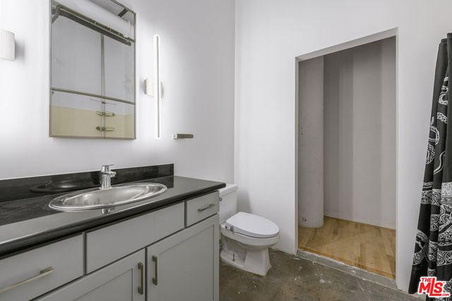a bathroom with a granite countertop sink a toilet and a mirror