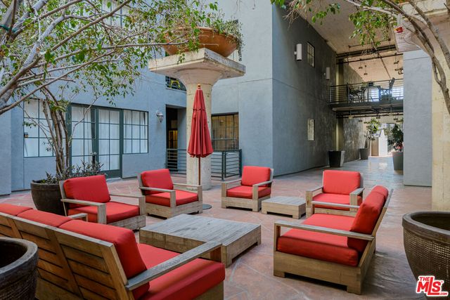 a outdoor space with the couches and dining table with the potted plants
