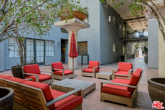 a outdoor space with the couches and dining table with the potted plants