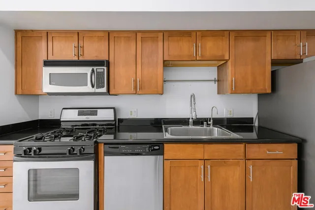 a kitchen with stainless steel appliances granite countertop a sink stove and microwave