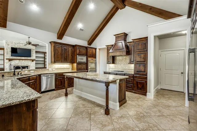 a kitchen with stainless steel appliances kitchen island granite countertop a sink and cabinets
