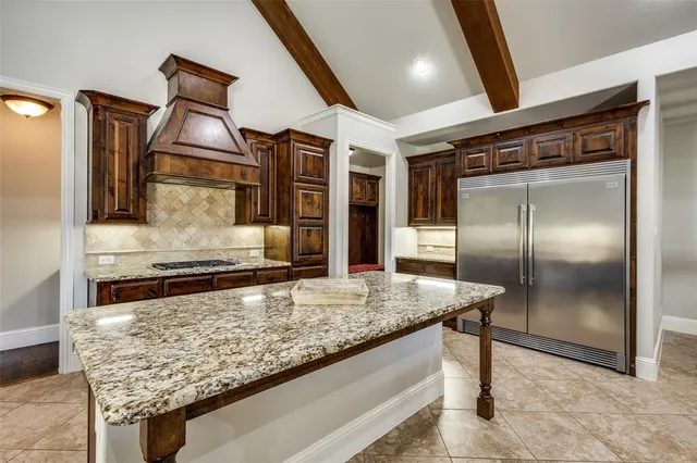 a kitchen with stainless steel appliances granite countertop a sink and a refrigerator