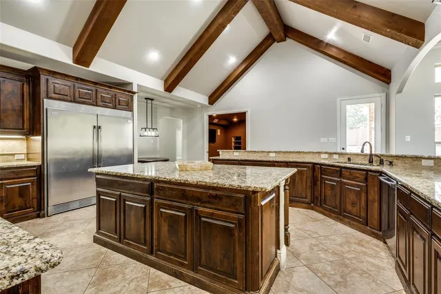 a kitchen with stainless steel appliances granite countertop a stove a sink and a refrigerator