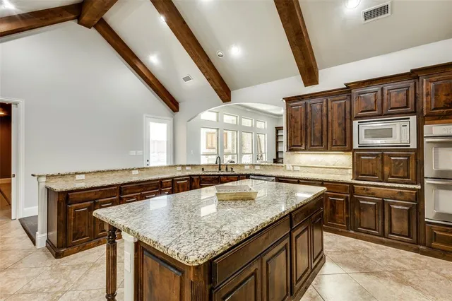 a kitchen with stainless steel appliances granite countertop a sink and a refrigerator