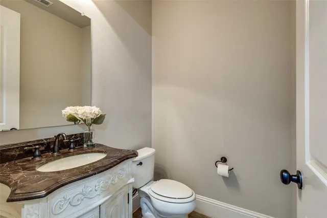 a bathroom with a granite countertop sink mirror and toilet