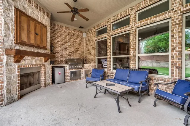a living room with furniture a fireplace and a floor to ceiling window