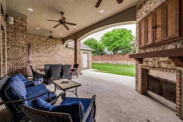 a living room with furniture a fireplace and a floor to ceiling window