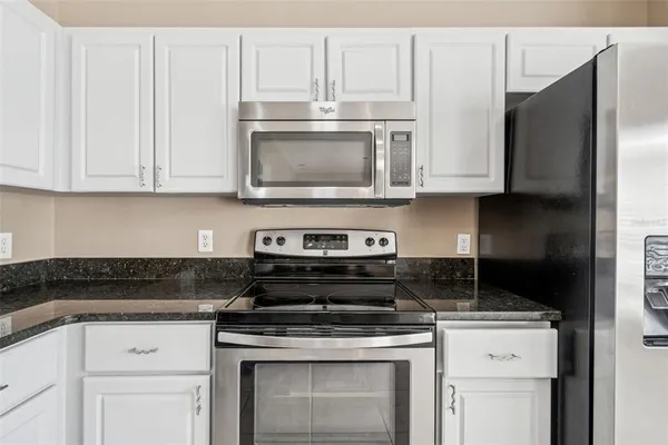 a view of an empty room with a chandelier fan