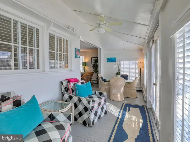 a large bed sitting in a bedroom next to a window and a chandelier