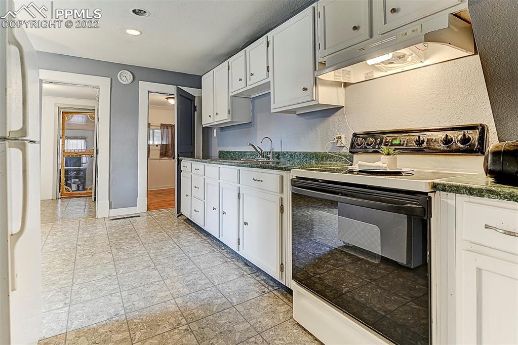 312 10th Street Fowler, CO 81039 - Photo 21 of 35 a kitchen with stainless steel appliances granite countertop a stove a sink and a microwave