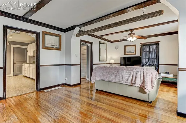 a spacious bedroom with a bed and wooden floor