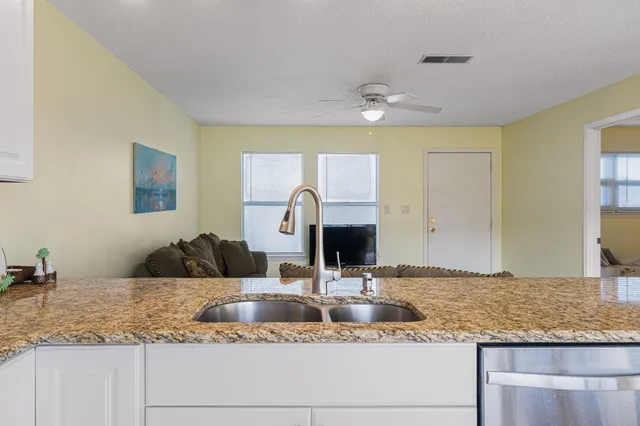 a kitchen with stainless steel appliances kitchen island granite countertop a dining table and chairs