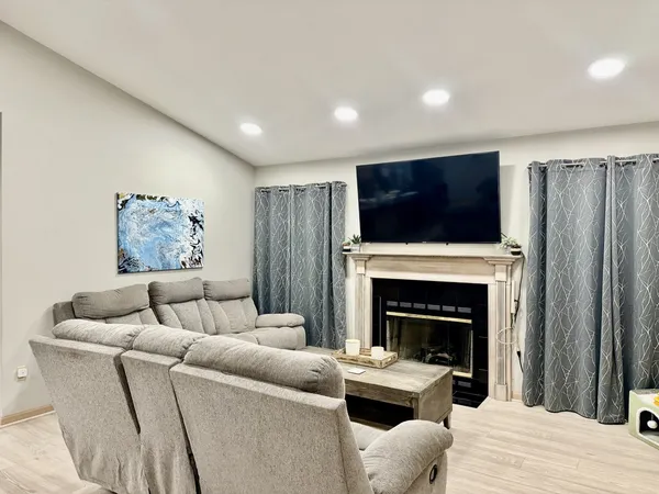 a living room with furniture a flat screen tv and a fireplace