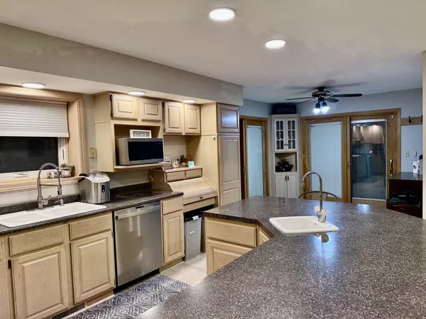 a large kitchen with kitchen island a sink stainless steel appliances and cabinets
