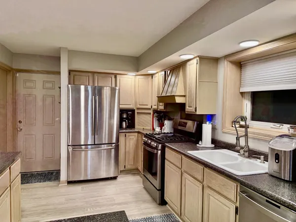 a kitchen with a refrigerator a stove and a sink