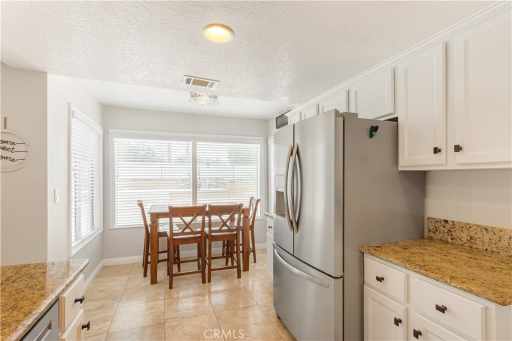 934 Mission Grove Riverside, CA 92506 - Photo 14 of 28 a kitchen with stainless steel appliances granite countertop a refrigerator and a table
