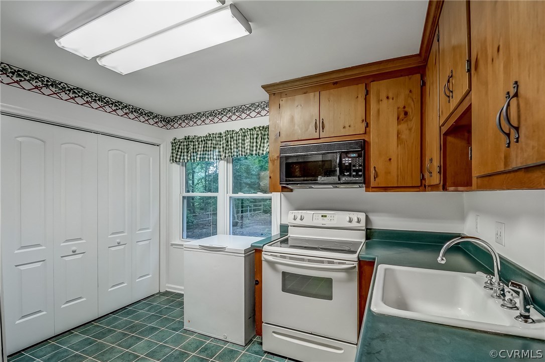 4906 Rollingway Road Chesterfield, VA 23832 - Photo 12 of 34 a kitchen with a sink a stove and cabinets